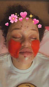 a woman is laying on a bed with a face mask on